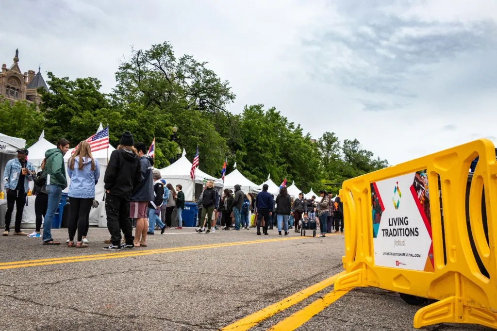 yellow crowd barrier with custom sign in use at living traditions festival slc 2019 1024x682 jpg