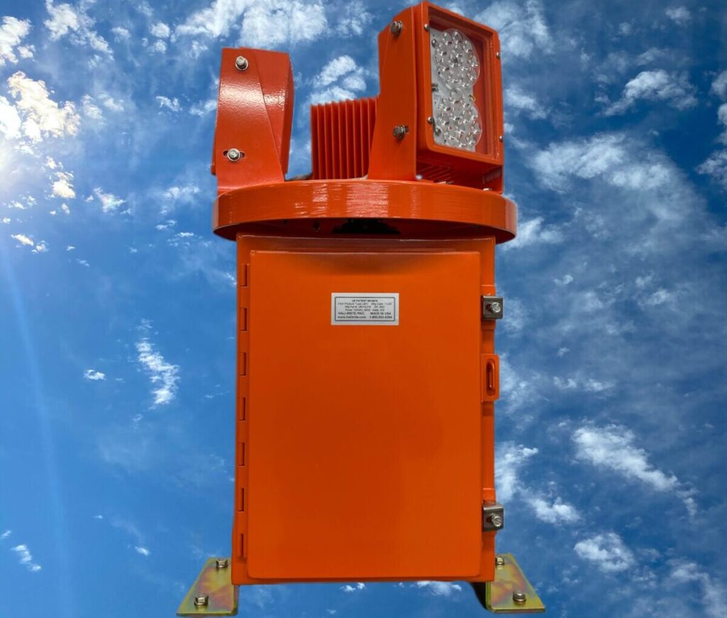 Rotating beacon in powder coated international orange on blue sky background