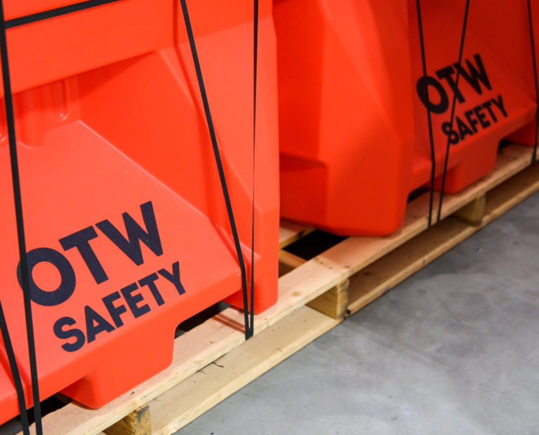 2 Safety orange small jersey barricades on a pallet, displaying OTW Safety Logo