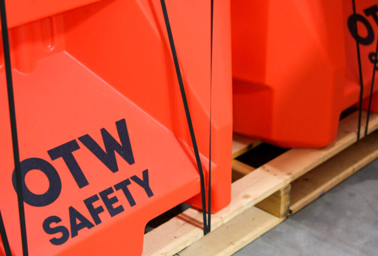 2 Safety orange small jersey barricades on a pallet, displaying OTW Safety Logo