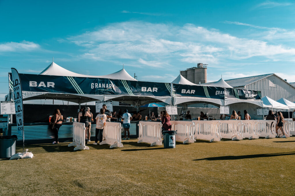 Crowd control lanes and bar tent on a blue sky day at Granary Live