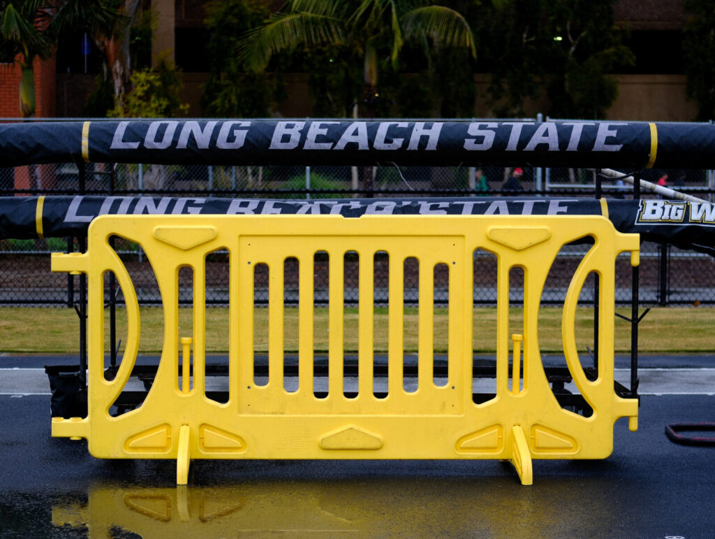 A yellow OTW barricade is set up outdoors at Long Beach State University