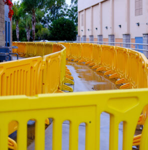 Yellow OTW school barricades are lined up to form a queue for students to follow.