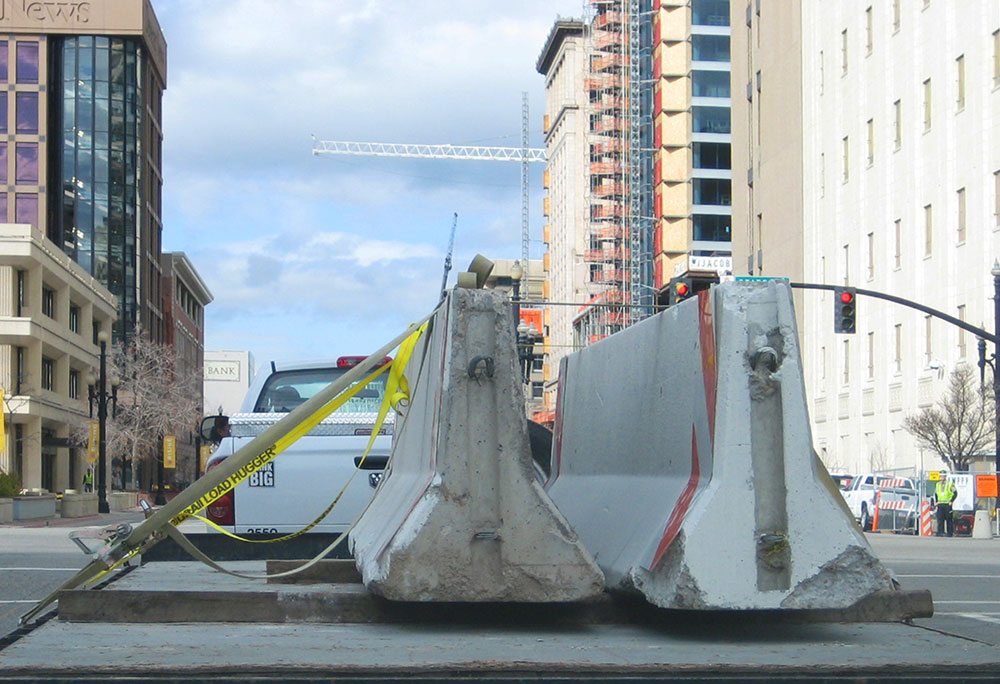 concrete jersey barriers being delivered on flatbed in city