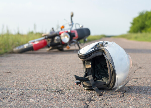 Motorcycle Accident Image, shows motorcycle laying in the road and helmet across the road