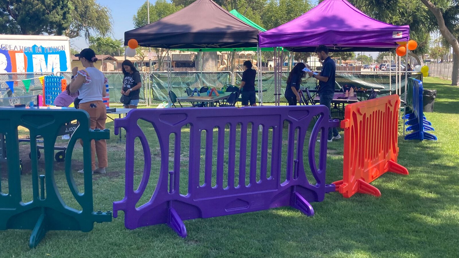 Purple, orange and green OTW block party barricades on a grassy lawn