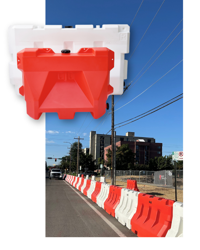 OTW Safety orange and white construction barricades lined up on a city street with buildings and power lines in the background