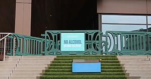 OTW green billboard barricade with a sign reading "No Alcohol Beyond This Point" at Gateway St Pattys Day Parade