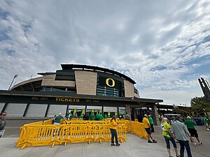 Yellow OTW Safety billboard barricades set outside entrance of Oregon Ducks game