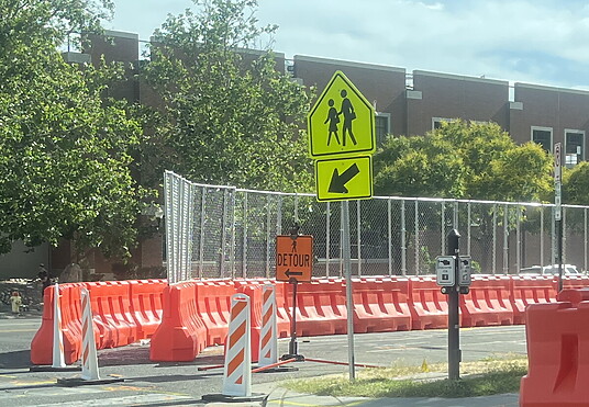 OTW Safety 42x72 orange plastic barricade creating a safe pedestrian walkway next to construction site.