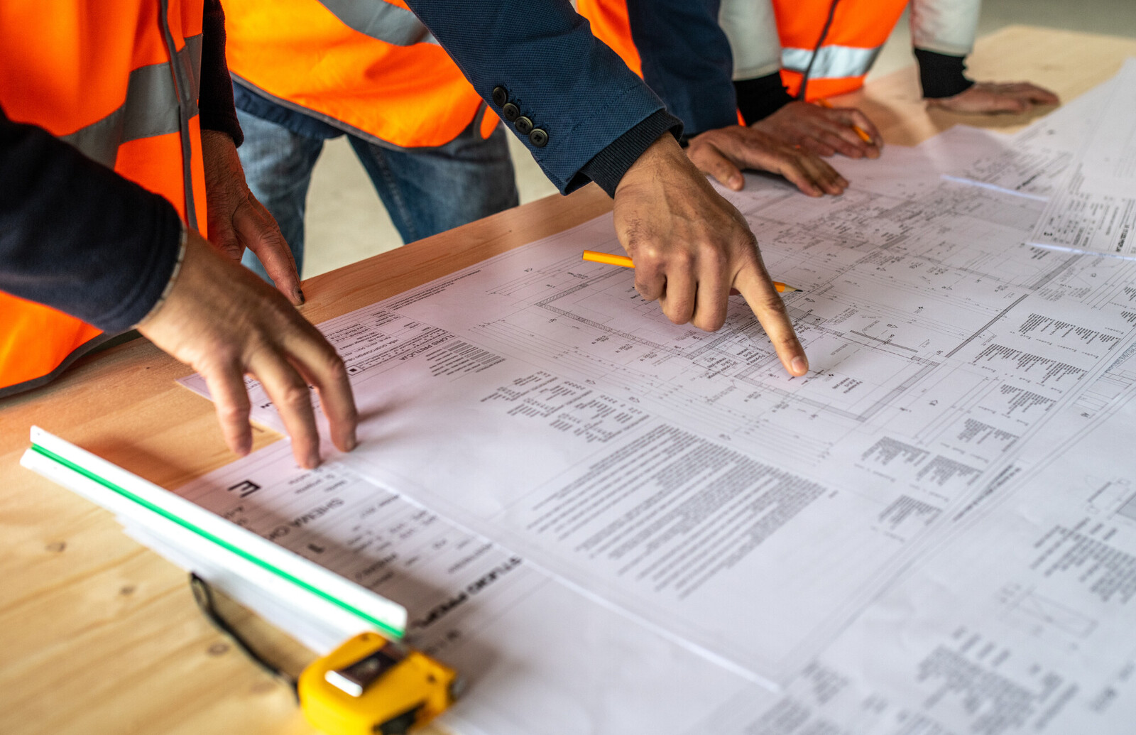 A group of contractors look over plans for a project.