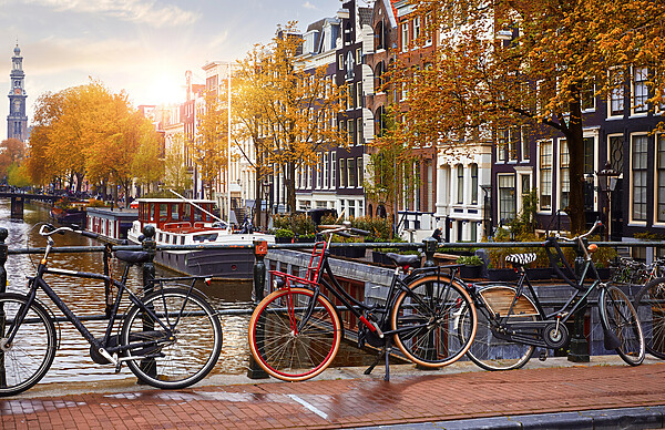 Three bicycles lean again a railing overlooking a canal