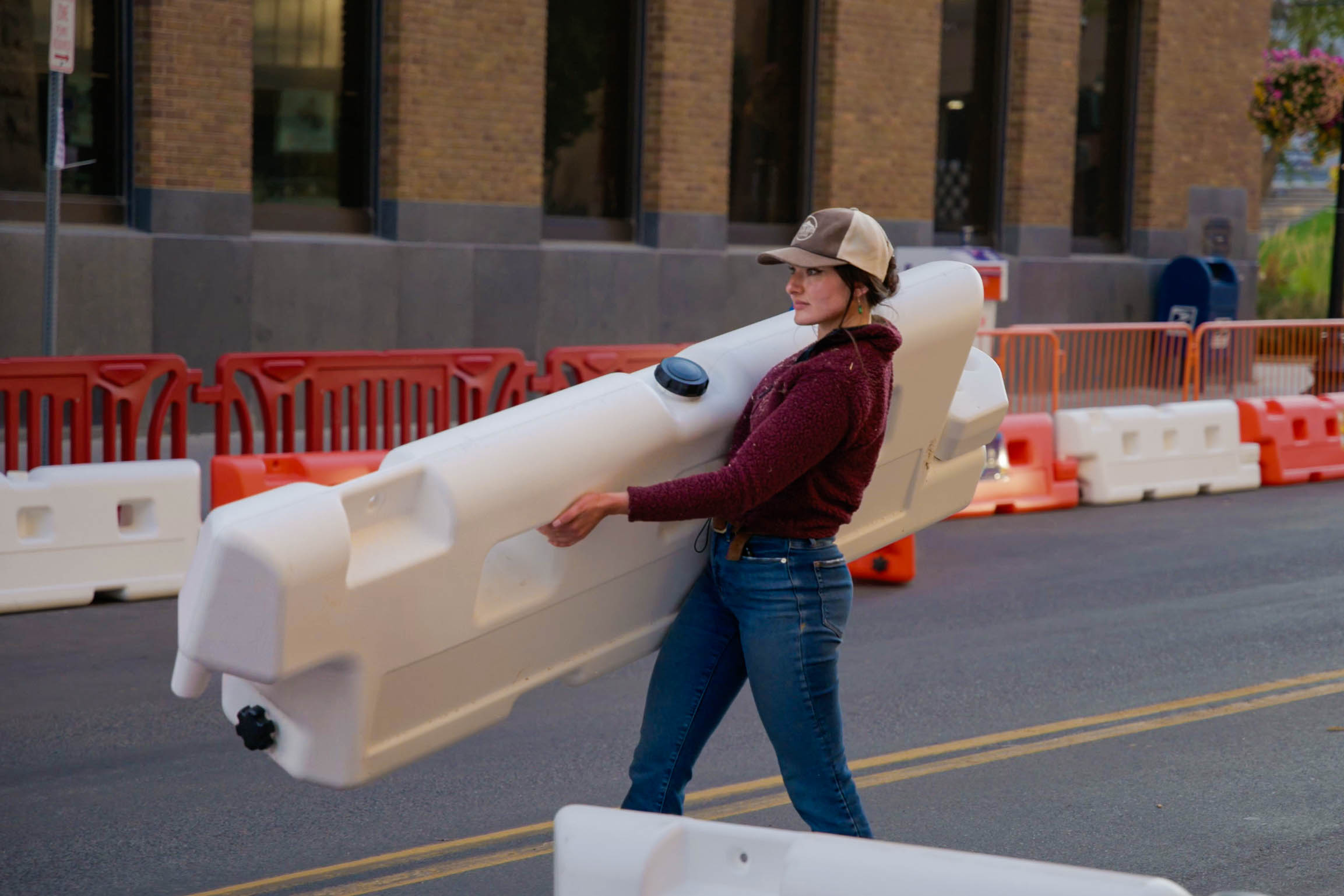 Woman carries OTW low-profile barricade in preparation for Go Karting event